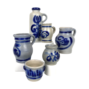 5 Keulse keramieken voorwerpen in blauw met crème zoals: 1 Kan (hoog 16 cm, diameter: 6 cm), genummerd 255516, chip aan onderkant + 2 Kannetjes met oor van 11 en 12 cm hoog + 1 Potje met twee oren, genummerd: 100, hoog: 6 cm, diameter: 7 cm + 1 Vaasje, hoog 7 cm, breed: 8 cm.