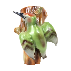 Keramieken vintage muurhanger met groene specht op boomstam. Genummerd: 8565. Vermoedelijk gemaakt in Tsjechië. Hoog: 12,5 cm. Breed: ca. 10 cm. In prachtige staat. Zonder beschadigingen.