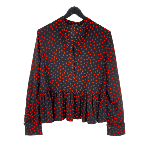 Polyester blouse met lange mouw van Nikkie. Maat 36. In zwart met 30de 6-kantige stip. (Polka Dot) Met knoopsluiting, brede manchetten en onderaan een geplooide strook. Lengte: 63 cm. Mouwlengte vanaf de schoudernaad: 62 cm. Oksel tot oksel: 49 cm. In uitstekende staat.